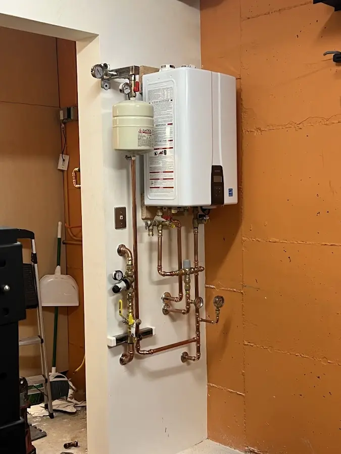 Plumbing technician inspecting water heater connections in Roanoke Rapids